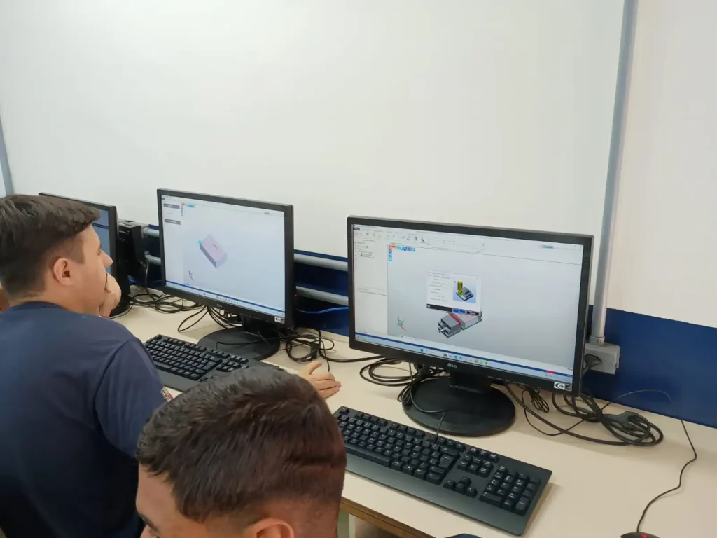 Imagem de estudantes do PIT mexendo no EDGECAM, software de usinagem para a manufatura inteligente