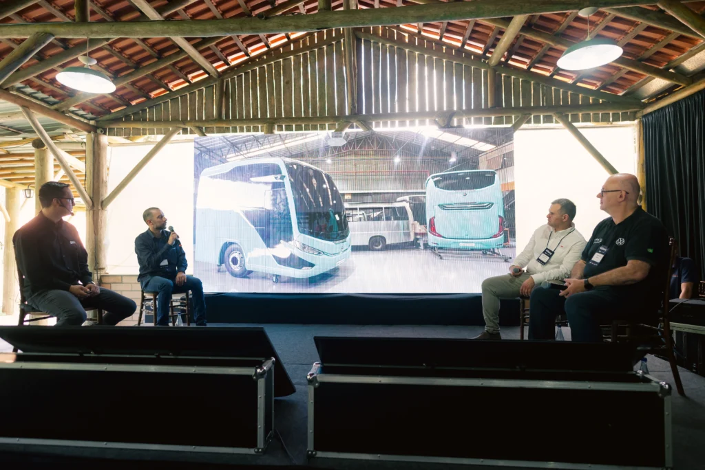 Foto dos represenantes SKA, Marcopolo e Volkswagen no palco do Encontro de WORKNC 2025